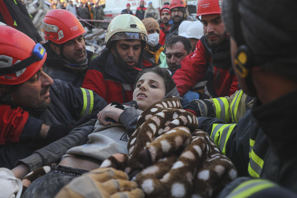 Rescatistas llevan a Muhammed Alkanaas, de 12 años, a una ambulancia después de sacarlo cinco días después del sismo, el sábado 11 de febrero de 2023, en Antakya, en el sur de Turquía. (AP Foto/Can Ozer)