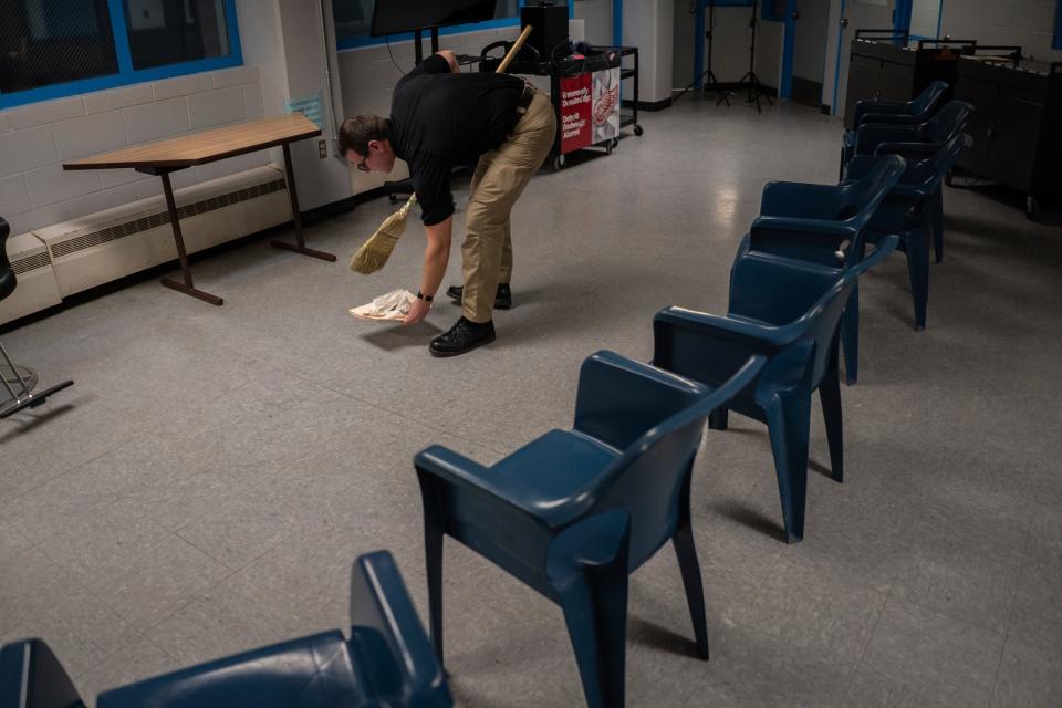 Deputy Nathaniel Minard, also a licensed barber, sweeps up hair after leading a one-hour hands-on barber course with a small group of incarcerated men as part of the I.G.N.I.T.E. (Inmate Growth Naturally and Intentionally Through Education) program held in an activities room of the Genesee County Jail in Flint on Thursday, Jan. 4, 2024.