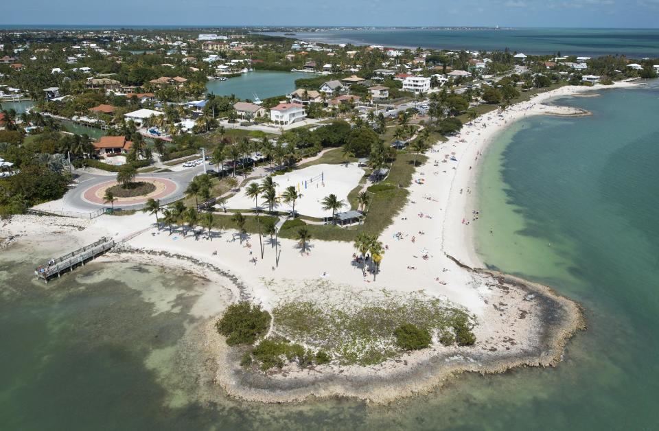 In this Sunday, March 10, 2013, photo provided by the Florida Keys News Bureau, Florida Keys residents and visitors enjoy Sombrero Beach Park in Marathon, Fla. The free-admission park includes volleyball courts, picnic pavilions, playground equipment, restrooms and showers. (AP Photo/Florida Keys News Bureau, Andy Newman)