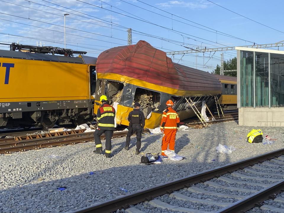 Firefighters stand by two trains that collided in Pardubice, Czech Republic Thursday, June 6, 2024. A passenger train collided head-on with a freight train in the Czech Republic, killing and injuring some people, officials said early Thursday. (AP Photo/Stanislav Hodina)