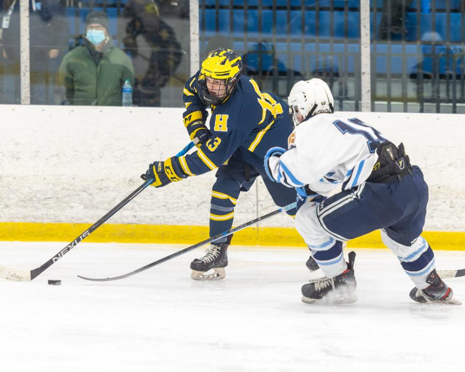 Hartland's Nick Halonen handles the puck while being defended by Livonia Stevenson's Andrew Elliott during the Eagles' 3-1 victory on Wednesday, Jan. 26, 2022 at Eddie Edgar Ice Arena.