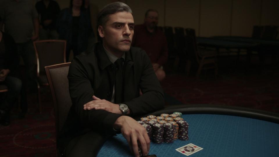 Oscar Isaac sitting at a poker table with a large stack of chips