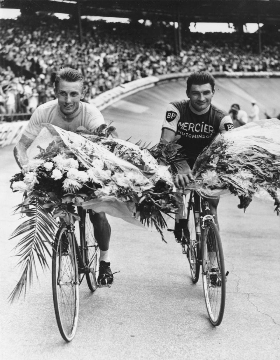 FILE - This July 14, 1964 file picture shows French cycling ace Jacques Anquetil, left, winning for the fifth time the Tour de France, as he rides an honor round with the Tour's second, Raymond Poulidor, at the Parc des Princes stadium in Paris, France. Tour de France organizers have confirmed that former rider Raymond Poulidor, known as "the eternal runner-up" behind five-time winners Jacques Anquetil and Eddy Merckx, has died. He was 83 years old. (AP Photo, File)