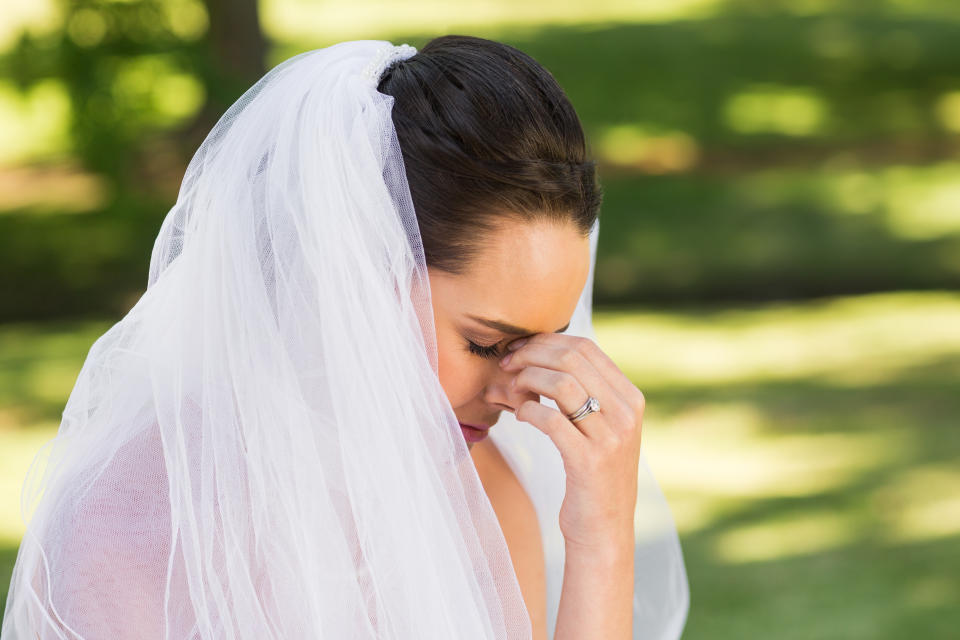 Close-up side view of a beautiful worried bride at the park