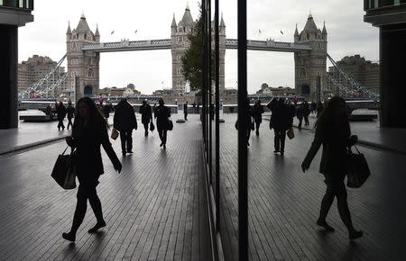Workers walk through the More London business district with Tower Bridge seen behind in London, November 11, 2015. REUTERS/Toby Melville