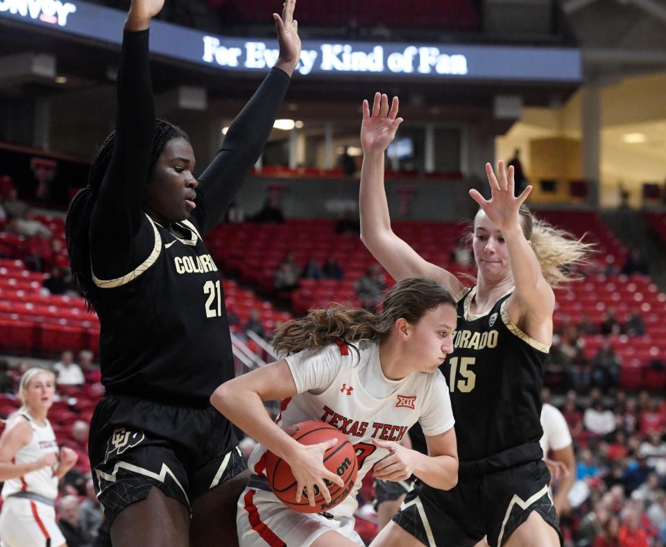 Texas Tech's guard Bailey Maupin (20), center, attempts to shoot the ball against Colorado in a preseason WNIT game, Wednesday, Nov. 16, 2022, at United Supermarkets Arena. 