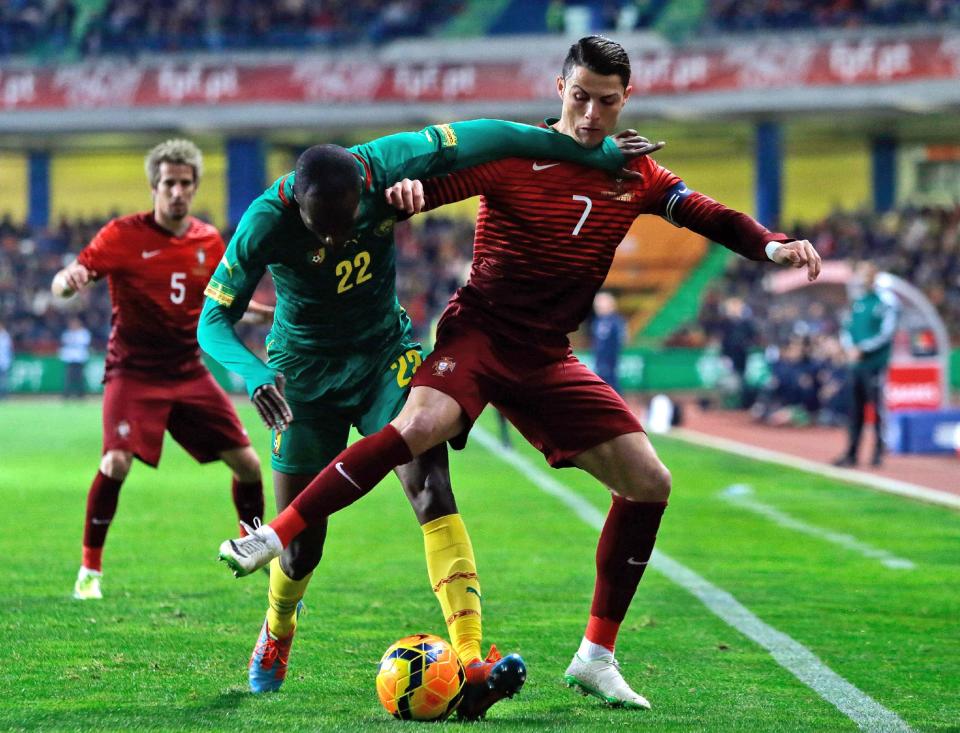 Portugal's Cristiano Ronaldo, right, fights for the ball with Cameroon's Allan Nyom during their friendly soccer match Wednesday, March 5 2014, in Leiria, Portugal. The game is part of both teams' preparation for the World Cup in Brazil. (AP Photo/Armando Franca)