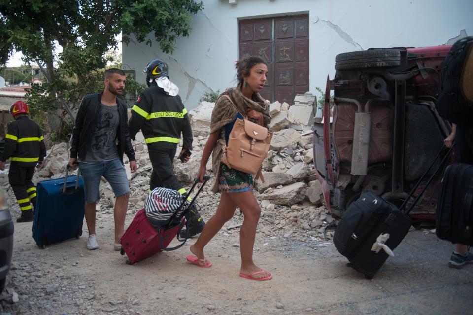 <p>People leave Casamicciola, the area most affected by the earthquake, on Aug. 22, 2017 in Casamicciola Terme, Italy. (Photo: Ivan Romano/Getty Images) </p>