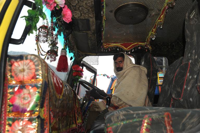 A stranded truck driver from Pakistan-administered Kashmir, looks on from the driver's seat of his truck at the Trade Facilitation Centre at Salambad in Uri, some 115 kilometres from Srinagar, on January 21, 2014