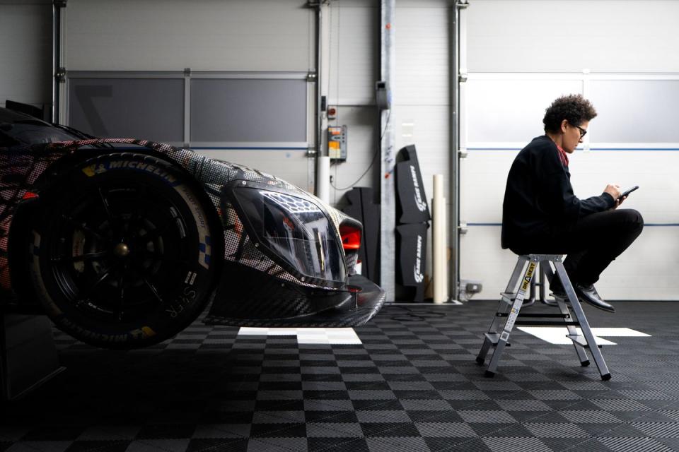 a man sitting on a chair next to a car