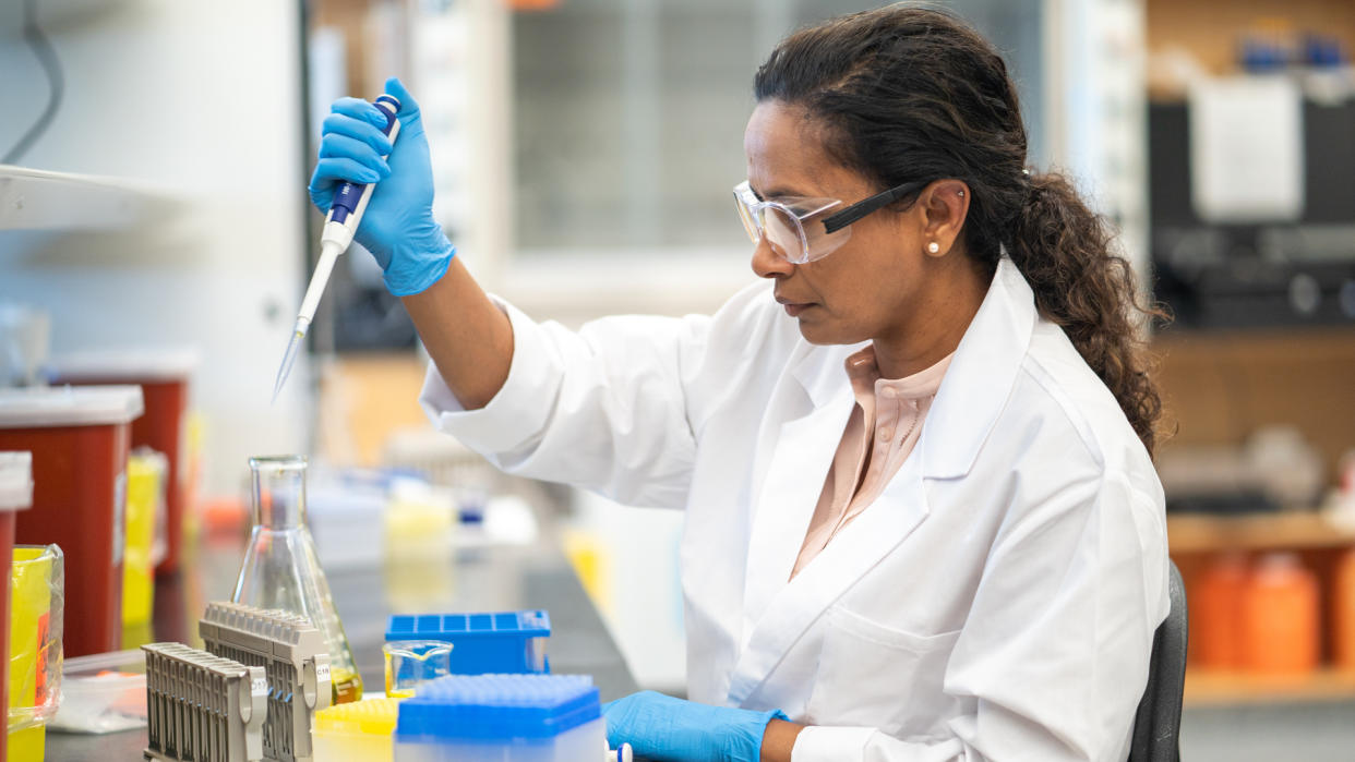 An ethnic female biochemist is working in a laboratory.