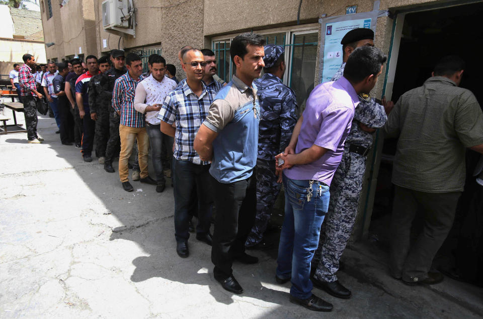 Iraqi security forces queue to vote outside a polling center in Baghdad, Iraq, Monday, April 28, 2014. As parliamentary elections are held Wednesday, more than two years after the withdrawal of U.S. troops, Baghdad is once again a city gripped by fear and scarred by violence. (AP Photo/ Karim Kadim)