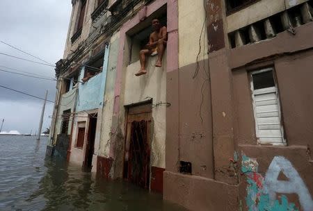 A man sits in the window of a flooded house, after the passing of Hurricane Irma, in Havana, Cuba September 10, 2017. REUTERS/Stringer