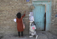 A health worker makes a mark on the door of a house after vaccinating the children of the family during a polio campaign in the old part of Kabul, Afghanistan, Tuesday, June 15, 2021. Gunmen on Tuesday targeted members of polio teams in eastern Afghanistan, killing a number of staffers, officials said. (AP Photo/Rahmat Gul)