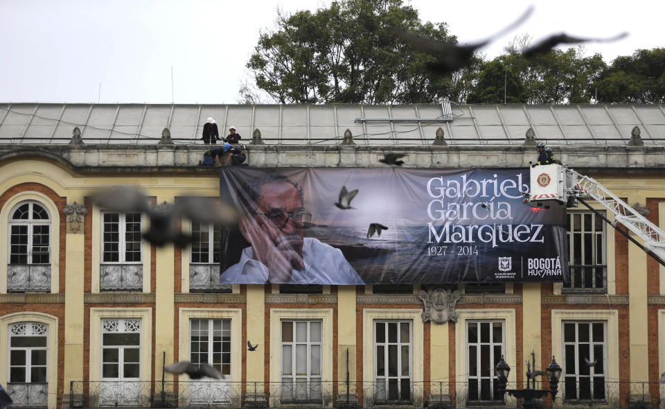 Un grupo de trabajadores cuelga un anuncio con una fotografía del fallecido Gabriel García Márquez sobre la alcaldía de Bogotá, Colombia, el martes 22 de abril de 2014. García Márquez, quien murió en la Ciudad de México el 17 de abril, es considerado uno de los más grandes escritores de la lengua española de todos los tiempos. (Foto AP/Fernando Vergara)