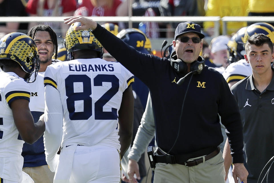 Michigan head coach Jim Harbaugh, right, congratulates tight end Nick Eubanks (82) after he caught a 7-yard touchdown pass against Alabama during the first half of the Citrus Bowl NCAA college football game, Wednesday, Jan. 1, 2020, in Orlando, Fla. (AP Photo/John Raoux)