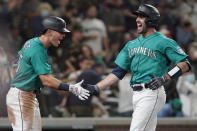 Seattle Mariners' Tom Murphy, right, is greeted by Dylan Moore after Murphy hit a solo home run during the sixth inning of the team's baseball game against the Arizona Diamondbacks, Friday, Sept. 10, 2021, in Seattle. The homer was Murphy's second in the game. (AP Photo/Ted S. Warren)