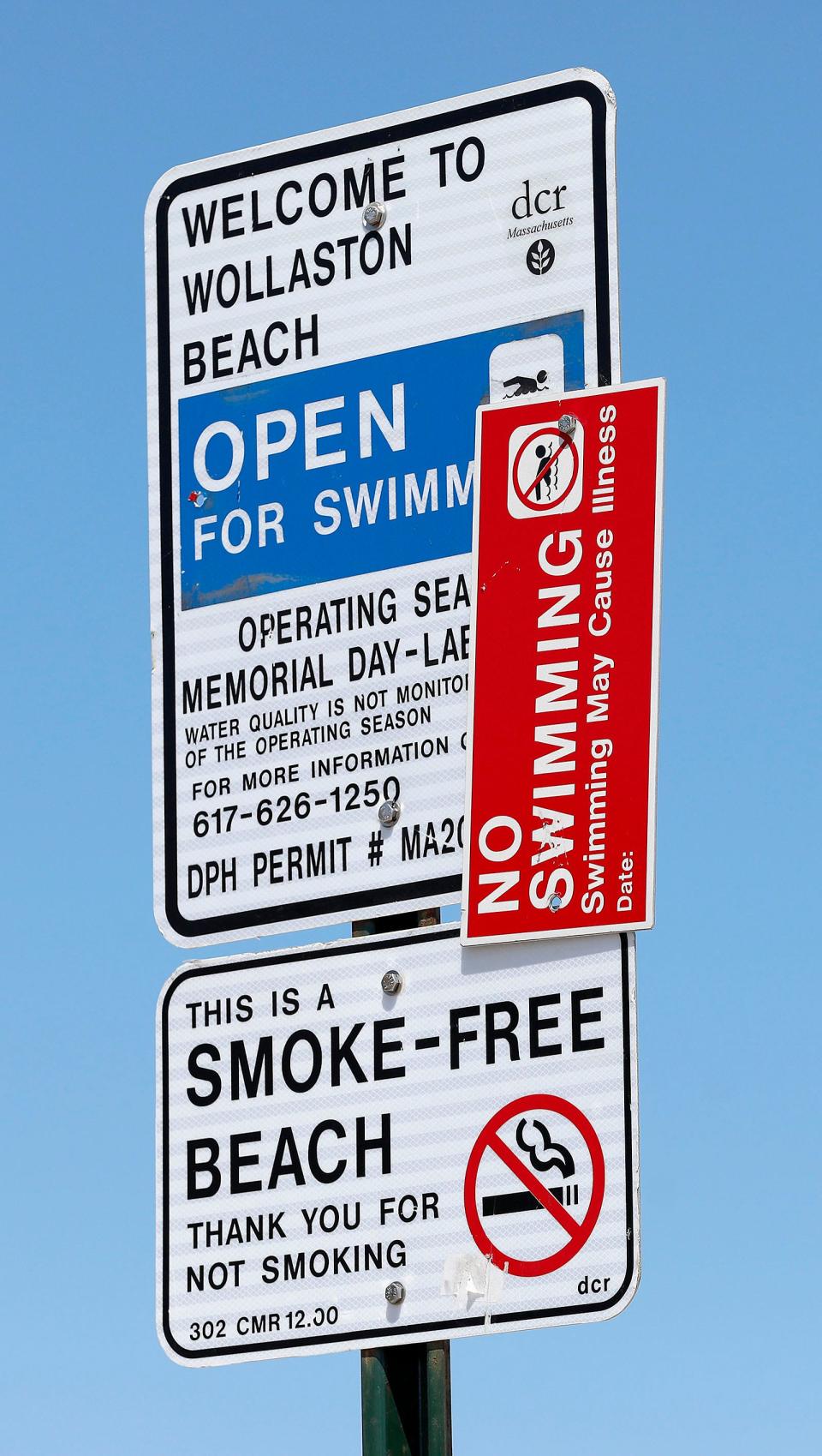 A sign informs Wollaston Beach goers about the water quality in Quincy on Wednesday, Aug. 3, 2022.