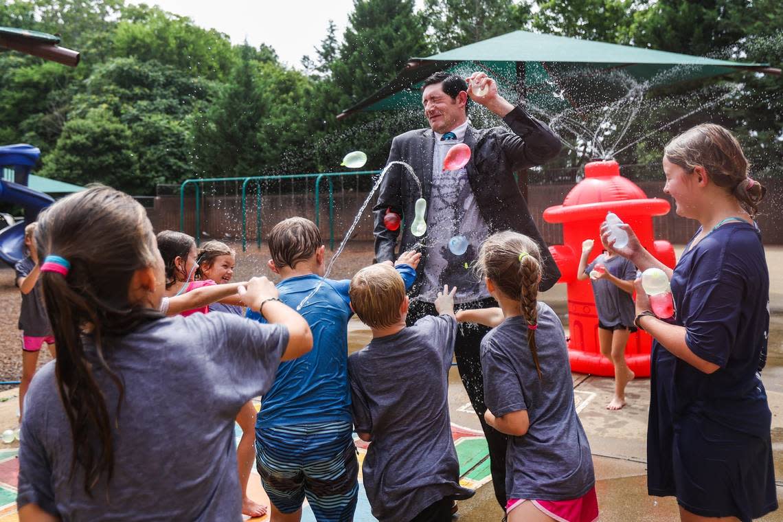 Kids collectively throw water balloons at the Superintendent for Catholic Schools for the Diocese of Charlotte, Dr. Gregory Monroe, during recess at summer camp at St. Matthew Catholic School on July 22, 2022 in Charlotte.