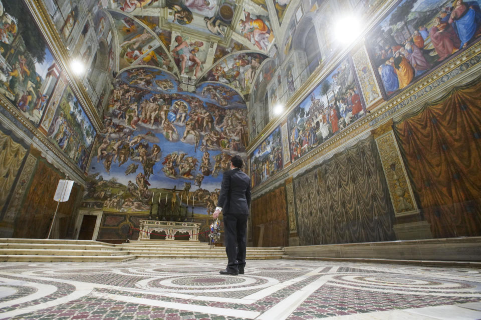 Gianni Crea, the Vatican Museums chief "Clavigero" key-keeper, walks through the Sistine Chapel as he opens the museum, at the Vatican, Monday, Feb. 1, 2021. Crea is the “clavigero” of the Vatican Museums, the chief key-keeper whose job begins each morning at 5 a.m., opening the doors and turning on the lights through 7 kilometers of one of the world's greatest collections of art and antiquities. The Associated Press followed Crea on his rounds the first day the museum reopened to the public, joining him in the underground “bunker” where the 2,797 keys to the Vatican treasures are kept in wall safes overnight. (AP Photo/Andrew Medichini)