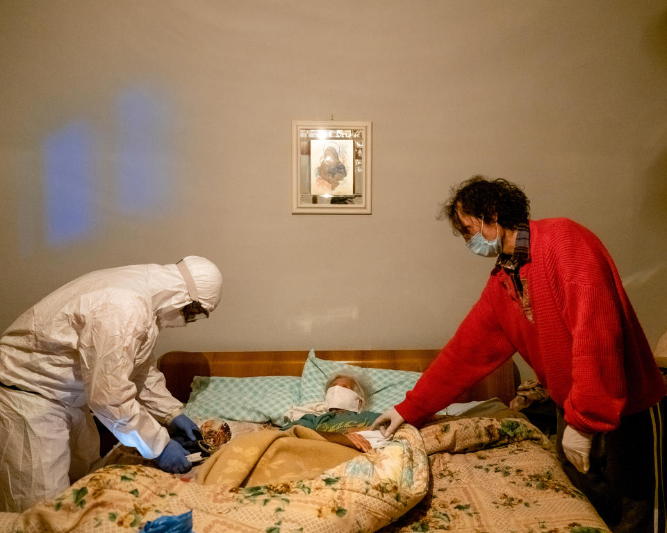 A health worker <a href="https://time.com/5822233/italy-coronavirus-photos/" rel="nofollow noopener" target="_blank" data-ylk="slk:checks an elderly woman's oxygen level;elm:context_link;itc:0;sec:content-canvas" class="link ">checks an elderly woman's oxygen level</a>, after receiving a call about a suspected COVID-19 case, in the northern Italian province of Bergamo.<span class="copyright">Lorenzo Meloni—Magnum Photos for TIME</span>