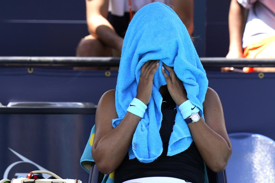 Naomi Osaka, of Japan, covers her head with a towel during her quarterfinal match against Maria Sakkari, of Greece, at the Miami Open tennis tournament, Wednesday, March 31, 2021, in Miami Gardens, Fla. Sakkari won 6-0, 6-4. (AP Photo/Lynne Sladky)