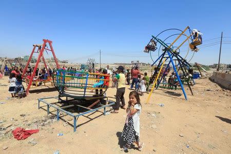 Iraqi children play as they celebrate Eid al-Fitr, in Mosul, Iraq June 25, 2017. REUTERS/Alaa Al-Marjani