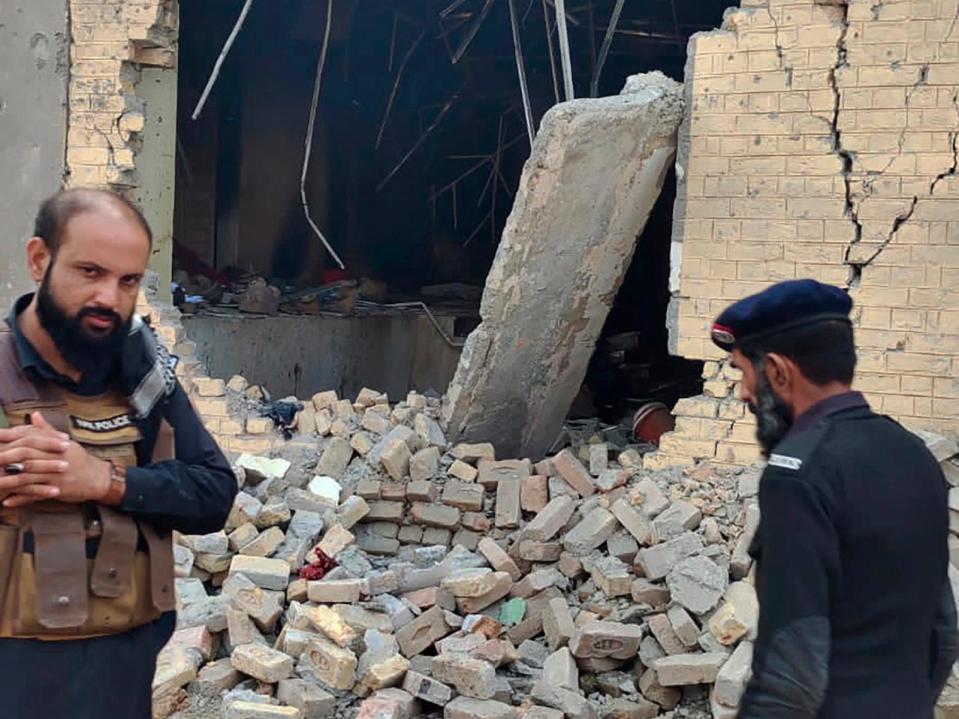 PHOTO: Police officers examine damages on the site of a bombing at a police station on the outskirts of Dera Ismail Khan, Pakistan, Tuesday, Dec. 12, 2023. (AP)