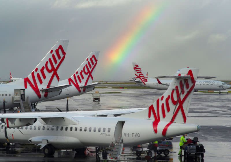 A rainbow from a passing rain shower sits over Virgin Australia aircraft at Sydney's Airport in Australia