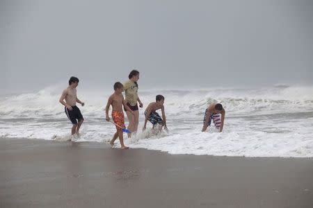 Children play in the surf of Hurricane Arthur, at the west end of Ocean Isle Beach, North Carolina July 3, 2014. REUTERS/Randall Hill