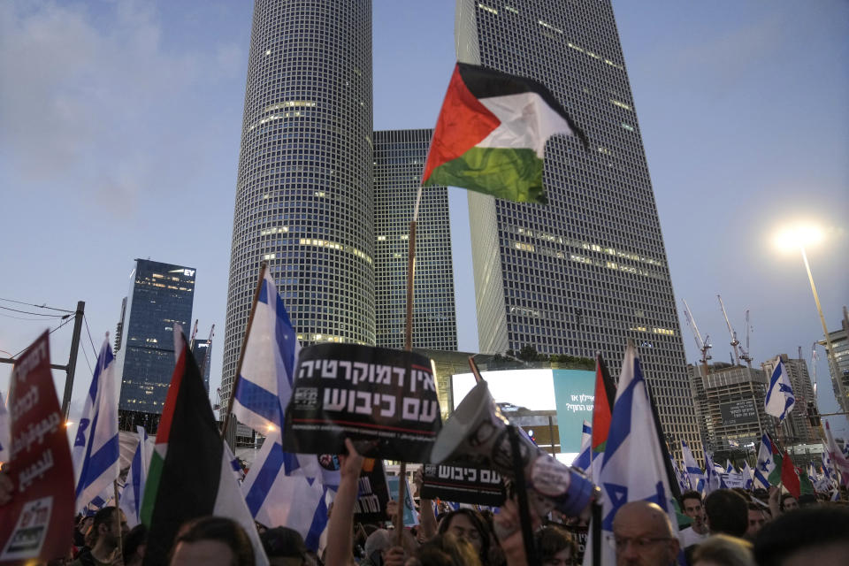 Demonstrators wave the Israeli and Palestinian flags during a protest against plans by Prime Minister Benjamin Netanyahu's government to overhaul the judicial system, in Tel Aviv, Israel, Saturday, July 22, 2023. (AP Photo/Mahmoud Illean)