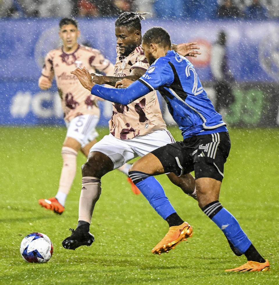 CF Montreal's George Campbell, right, challenges Portland Timbers' Dairon Asprilla, front left, during second-half MLS soccer match action in the rain in Montreal, Saturday, Oct. 7, 2023. (Graham Hughes/The Canadian Press via AP)