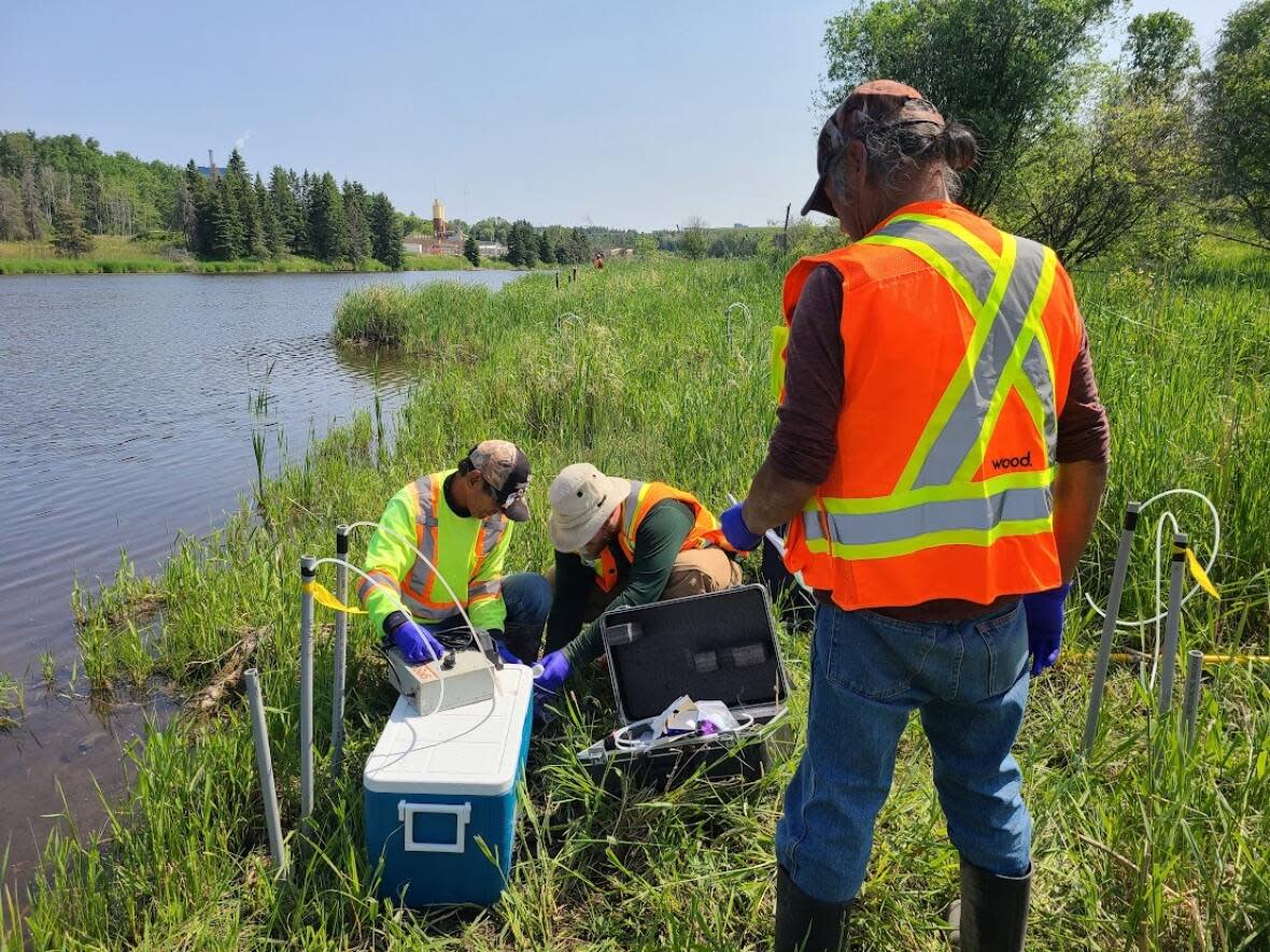 People are seen collecting samples from the English-Wabigoon River in northwestern Ontario as part of an experiment looking at levels of methylmercury in the water. The study found that large amounts of sulfate and organic matter in the industrial wastewater pouring into the river has fed the amount of methylmercury in the system. (Submitted by Brian Branfireun - image credit)