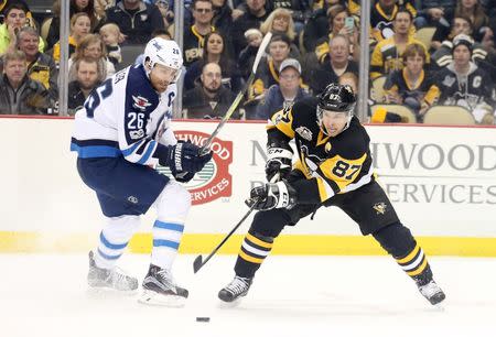 Feb 16, 2017; Pittsburgh, PA, USA; Pittsburgh Penguins center Sidney Crosby (87) reaches for the puck against Winnipeg Jets right wing Blake Wheeler (26) during the first period at the PPG PAINTS Arena. Charles LeClaire-USA TODAY Sports