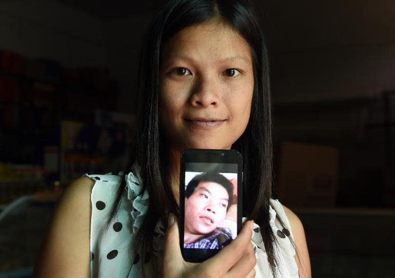 Vietnamese bride Vu Thi Hong Thuy poses with a photo of her Chinese husband in Weijian village, China's Henan province on July 30, 2014