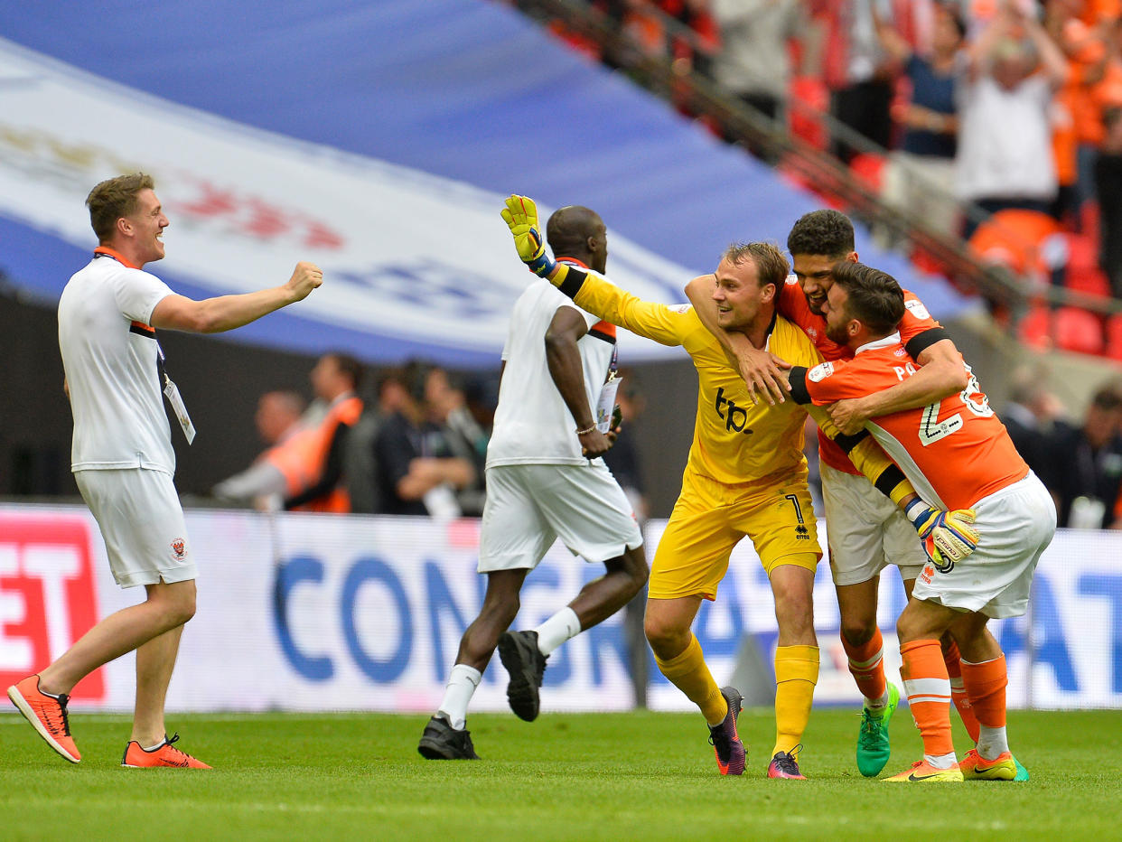 Blackpool's players celebrate securing their return to League One: Getty