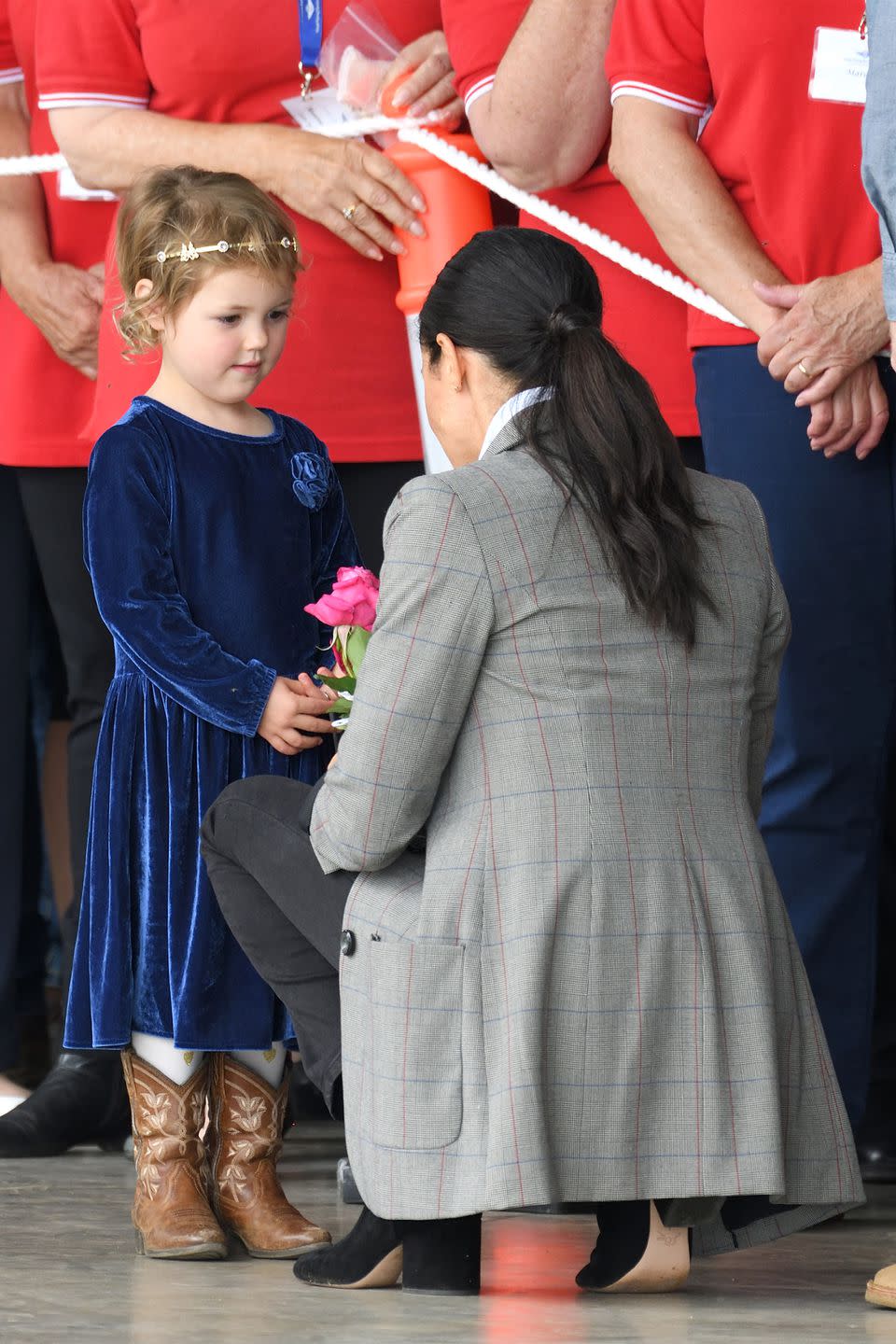 <p>Meghan receives a flower from a young fan.</p>