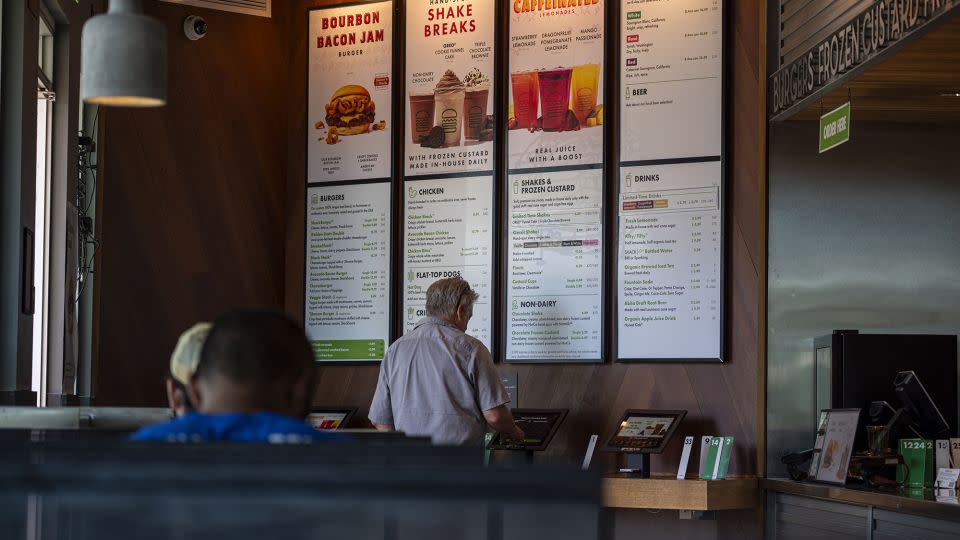 A customer orders food at a kiosk in a Shake Shack restaurant in Larkspur, California, on Thursday, July 20, 2023. - David Paul Morris/Bloomberg/Getty Images