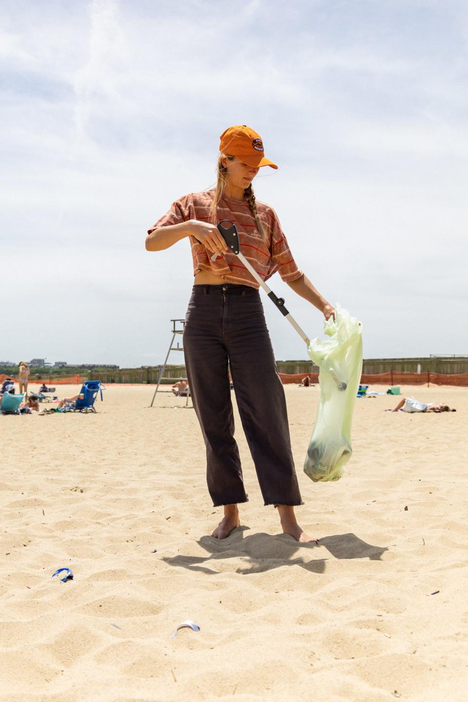 Professional surfer Anna Gudauskus picks up trash as part of a series of beach cleanups to raise awareness about the threats of pollution.