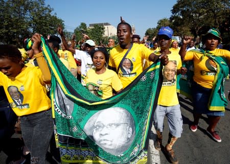 Supporters of former President Jacob Zuma sing as he appears in the High Court where he faces charges that include fraud, corruption and racketeering