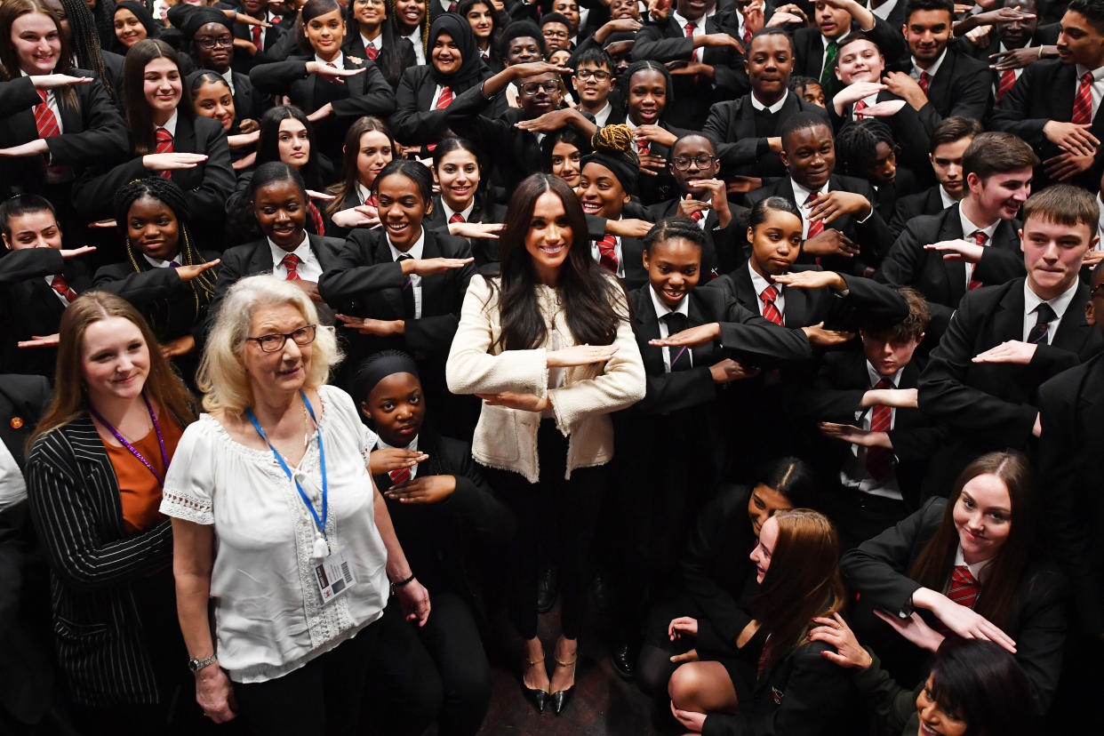 The Duchess of Sussex (centre) poses with school children making the 'equality' sign following a school assembly during a surprise visit to the Robert Clack Upper School in Dagenham, Essex, to celebrate International Women's Day. PA Photo. Picture date: Friday March 6, 2020. Meghan visited the school, addressing 700 pupils in an assembly ahead of the worldwide celebration of women's achievements on Sunday. Head boy Aker Okoye, 16, was later invited on stage with the duchess after swiftly volunteering to give his view on why men need to be involved in the fight for women's equality. See PA story ROYAL Meghan. Photo credit should read: Ben Stansall/PA Wire