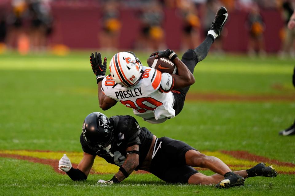Oklahoma State wide receiver Brennan Presley (80) is tackled by Iowa State defensive back Jeremiah Cooper (4) during the second half of Saturday's game in Ames, Iowa.