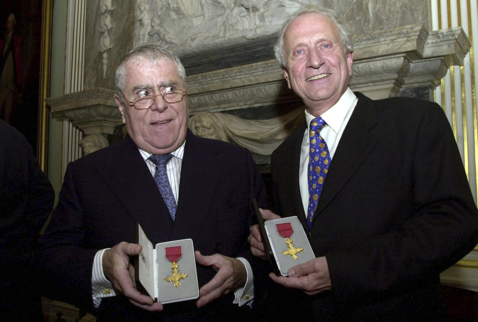 FILE - In this Oct. 31, 2002 file photo, Albert, left and Michel Roux display their honourary OBE medals presented to them by the British Foreign Secretary Jack Straw, on behalf of Britain's Queen Elizabeth, at a ceremony at the Foriegn and Commonwealth offices in central London. Albert Roux, the French-born chef and restaurateur who along with his late brother Michel had a profound influence on British dining habits, has died. He was 85, it was reported on Wednesday, Jan. 6, 2021. The brothers are widely credited with revolutionizing Britain’s staid and old-fashioned culinary scene, notably with their opening of Le Gavroche in London in 1967, a restaurant that was frequented by a loyal clientele that included many of the icons of the Swinging Sixties in London. (Johnny Green/PA via AP, File)