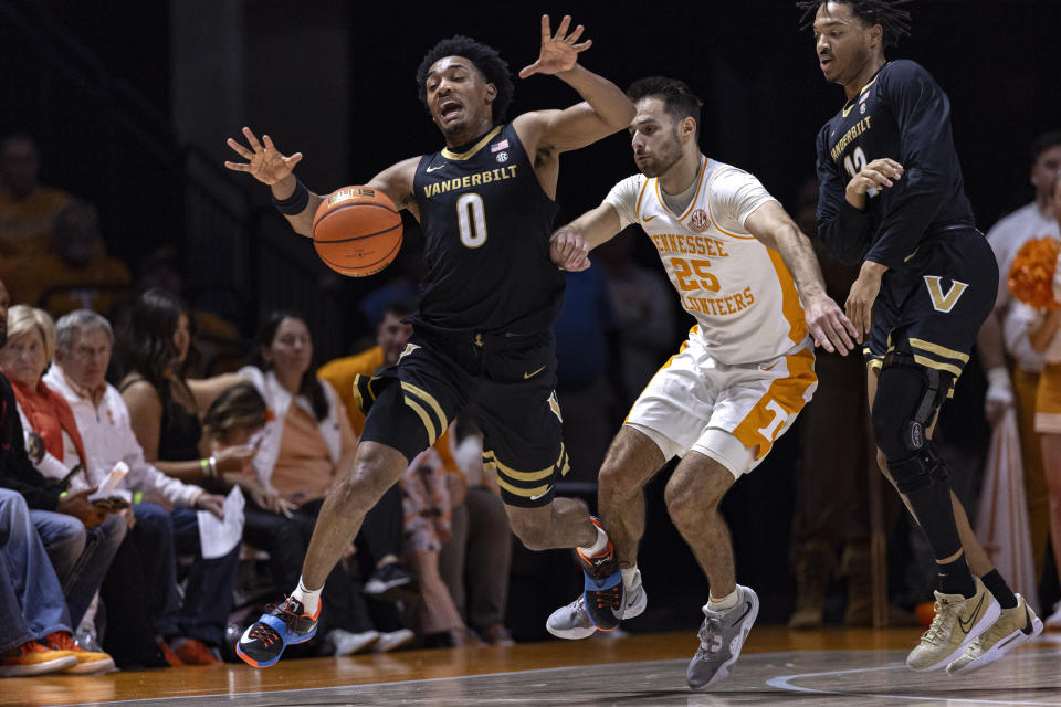 Vanderbilt guard Tyrin Lawrence (0) has the ball knocked away by Tennessee guard Santiago Vescovi (25) during the first half of an NCAA college basketball game Saturday, Feb. 17, 2024, in Knoxville, Tenn. (AP Photo/Wade Payne)