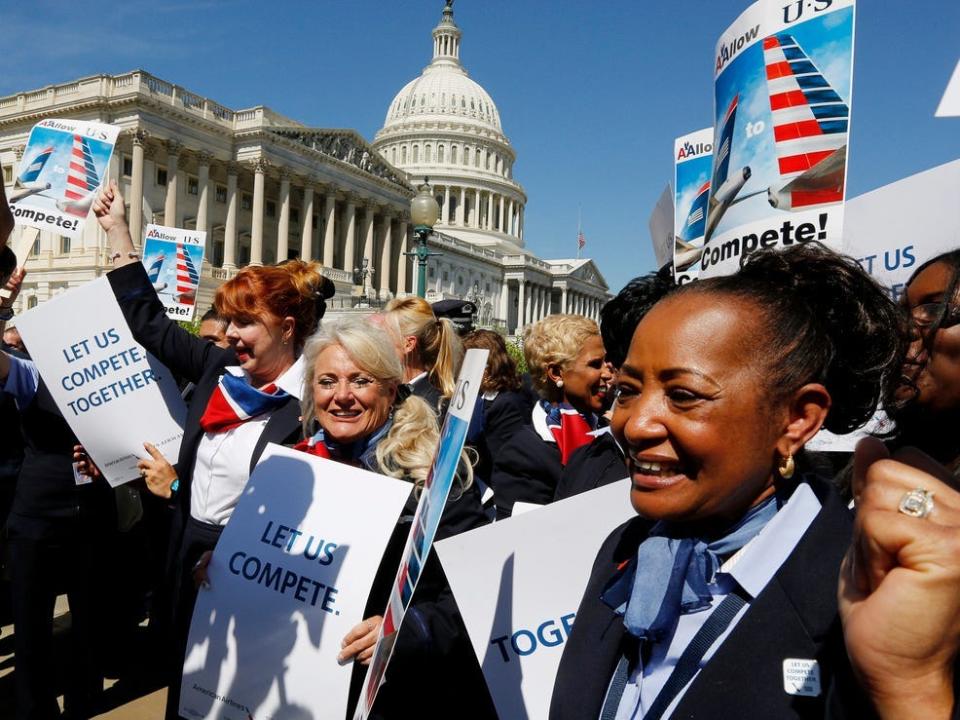 Pilots, flight attendants, baggage handlers and other union members working for American Airlines and US Airways demonstrate urging the U.S. Justice Department to allow the two companies to merge.