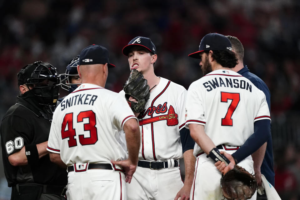 Atlanta Braves starting pitcher Max Fried (54) pulls on his lip as manager Brian Snitker (43) relieves him in the seventh inning of a baseball game against the New York Mets, Monday, May 17, 2021, in Atlanta. (AP Photo/John Bazemore)