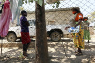 Community health worker, Rosemary Rambire, right, speaks to a young girl during a COVID-19 awareness campaign in Chitungwiza, on the outskirts of Harare, Wednesday, Sept. 23, 2020. As Zimbabwe's coronavirus infections decline, strict lockdowns designed to curb the disease are being replaced by a return to relatively normal life. The threat has eased so much that many people see no need to be cautious, which has invited complacency. That worries some health experts. Rosemary Rambire says the improving figures and the start of the searing heat of the Southern Hemisphere’s summer could undermine efforts to beat back the virus even further. (AP Photo/Tsvangirayi Mukwazhi)