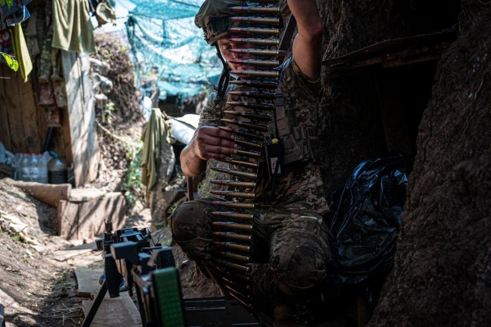 A Ukrainian soldier loads a machine gun inside a trench amid Russia and Ukraine war in Donetsk Oblast, Ukraine on August 17, 2023.