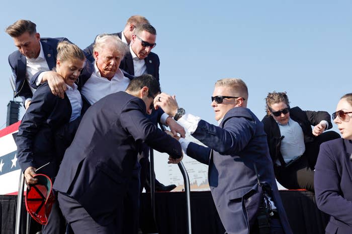 Donald Trump, surrounded by security, is being helped down stairs