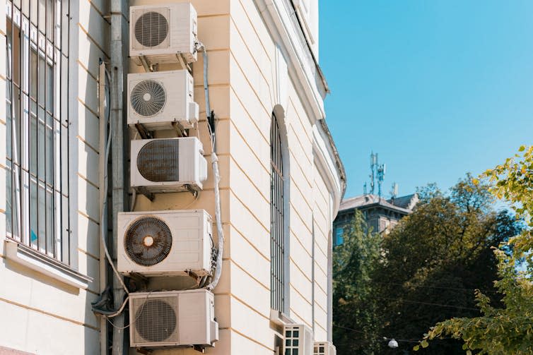 A column of air-conditioning units attached to the exterior of a building.